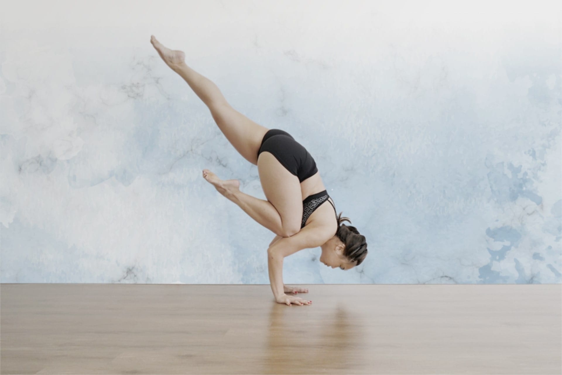 woman in black performing yoga position